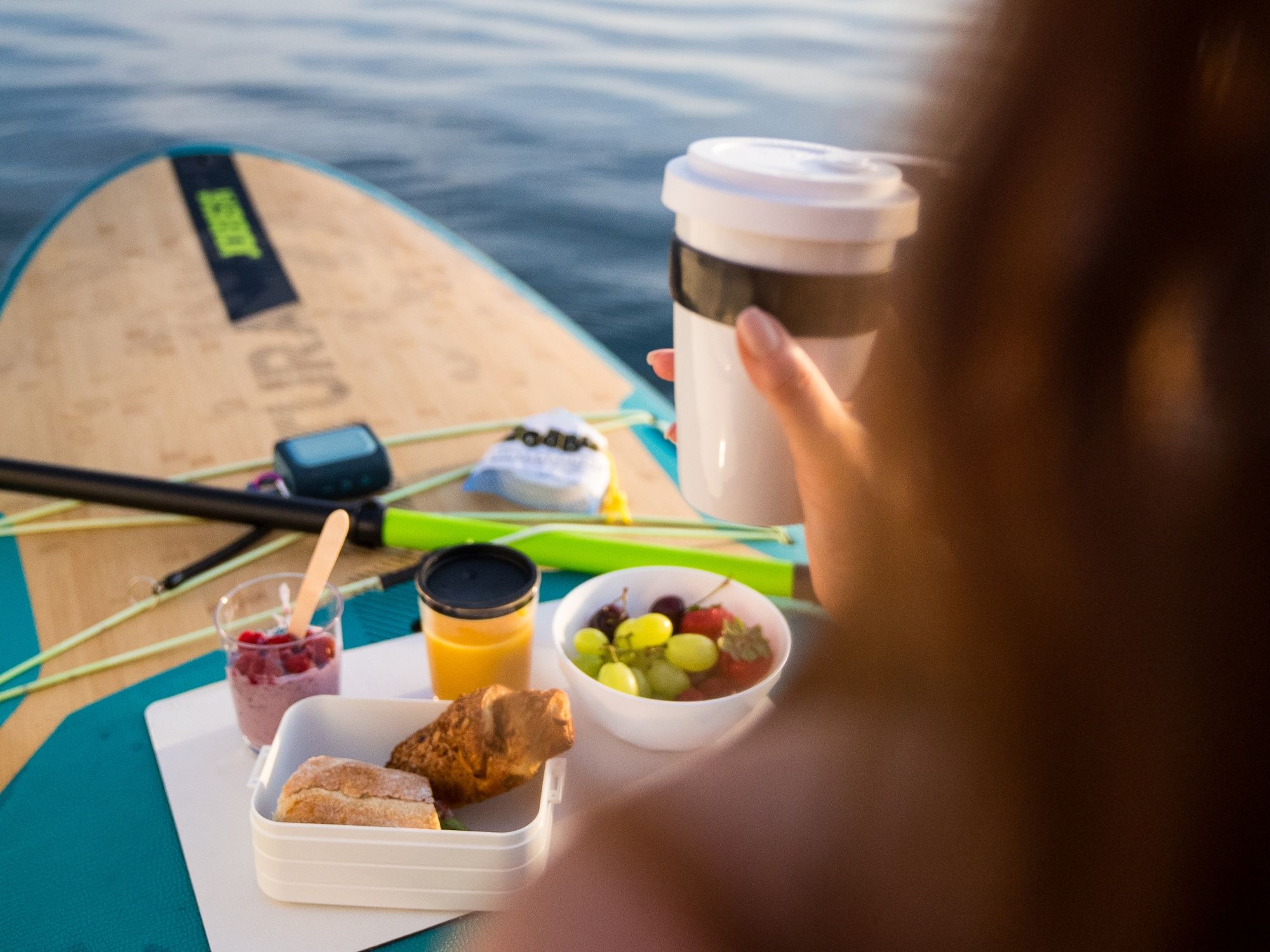 SUP desayuno con snacks sobre el agua, ideal para emocionantes días de verano mientras practicas Stand Up Paddle.