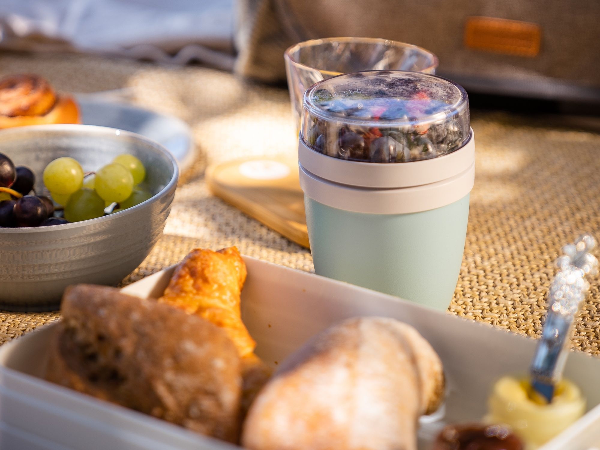 Colazione nel parco con frutta fresca e pasticcini nella natura, ideale per una giornata estiva rilassante.