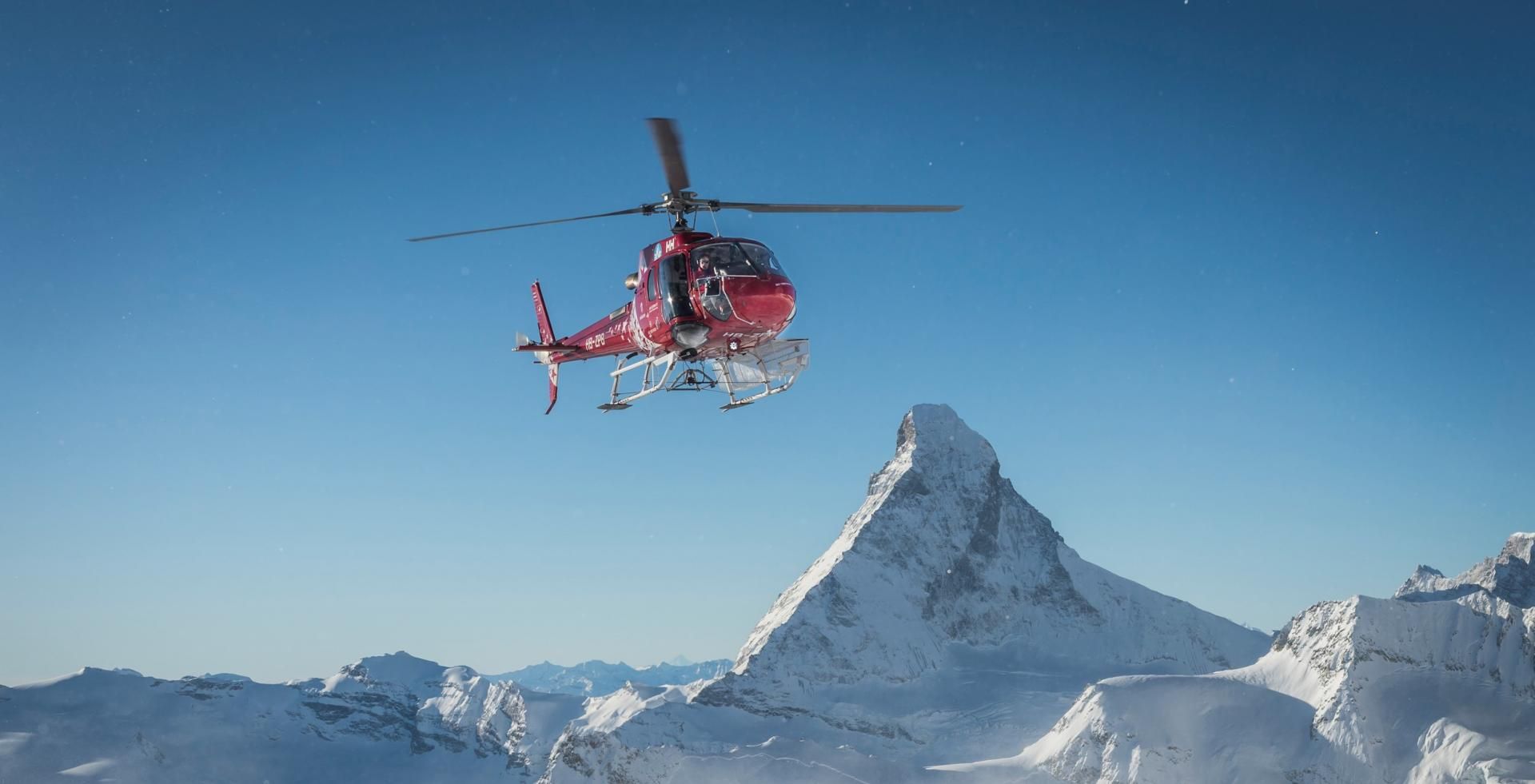 Helikopter snowboard freeride di pegunungan Zermatt selama musim dingin di pegunungan tinggi.