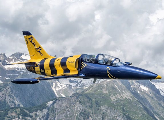 L39 Albatros: Un avión único sobre los Alpes en una pintura azul y amarilla durante un vuelo.