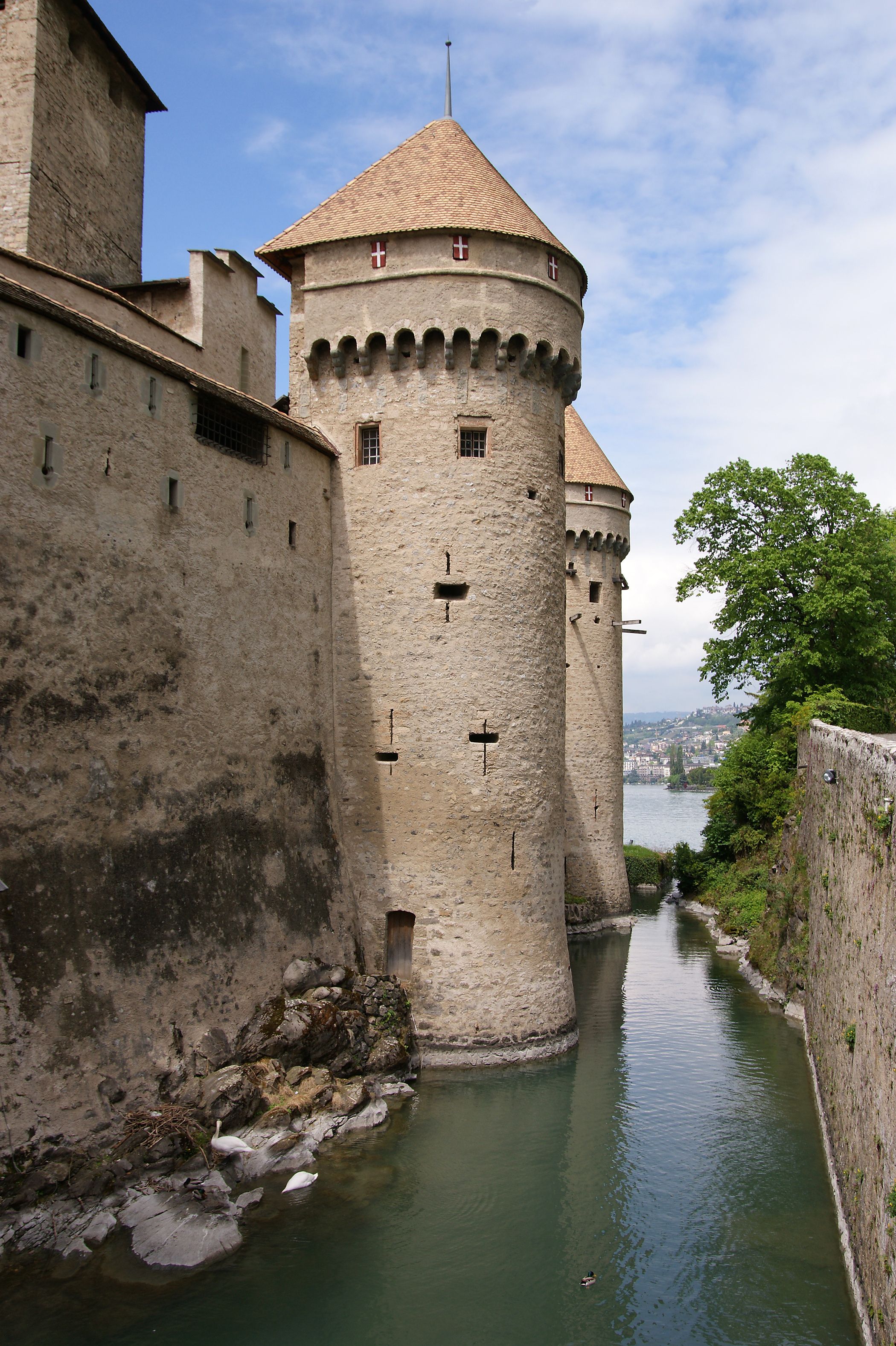 Chateau Chillon di Tasik Geneva dengan menara yang mencolok dan pokok-pokok