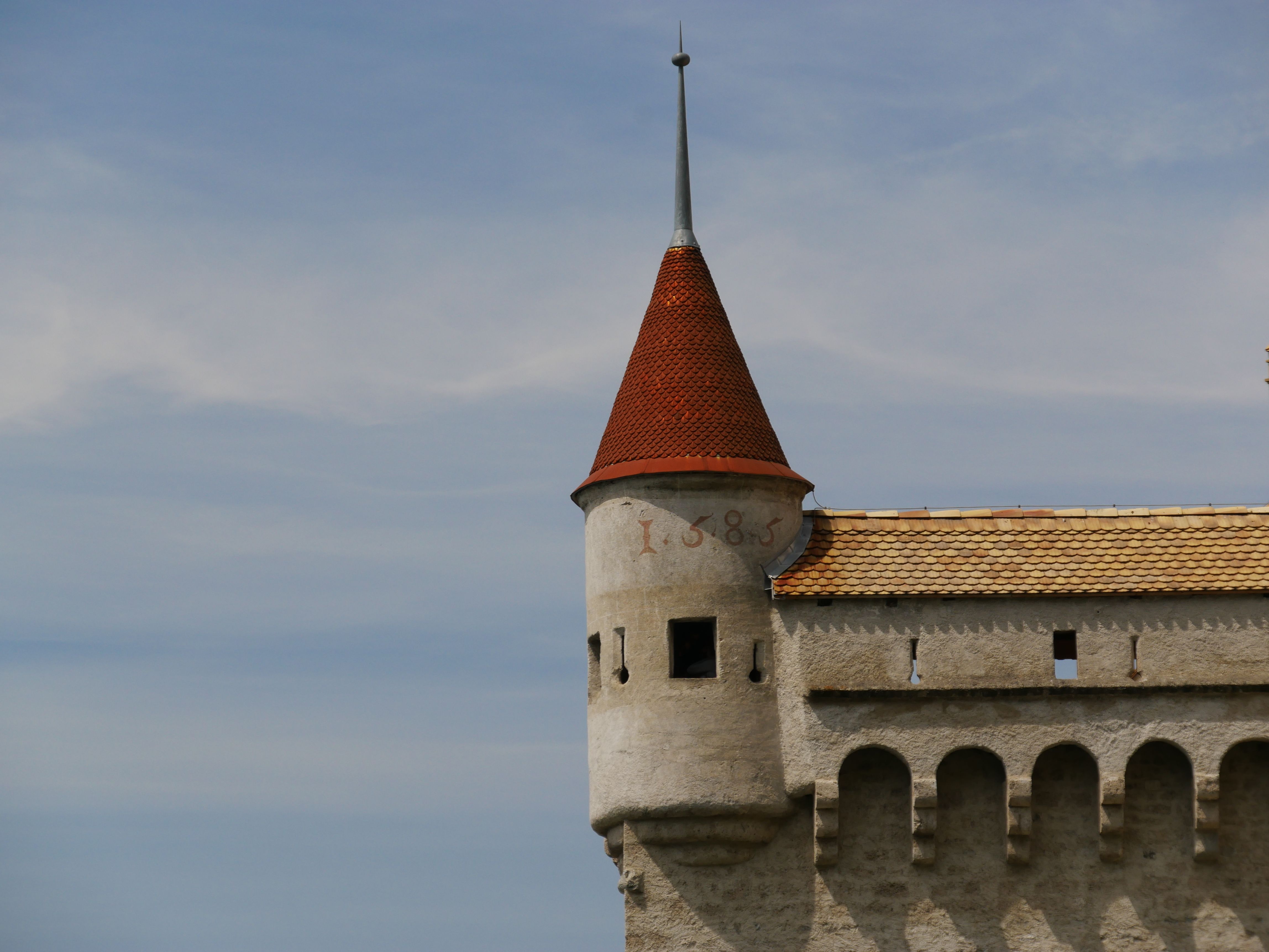 Chateau Chillon di Tasik Geneva dengan bumbung menara merah dan batu bata bersejarah.