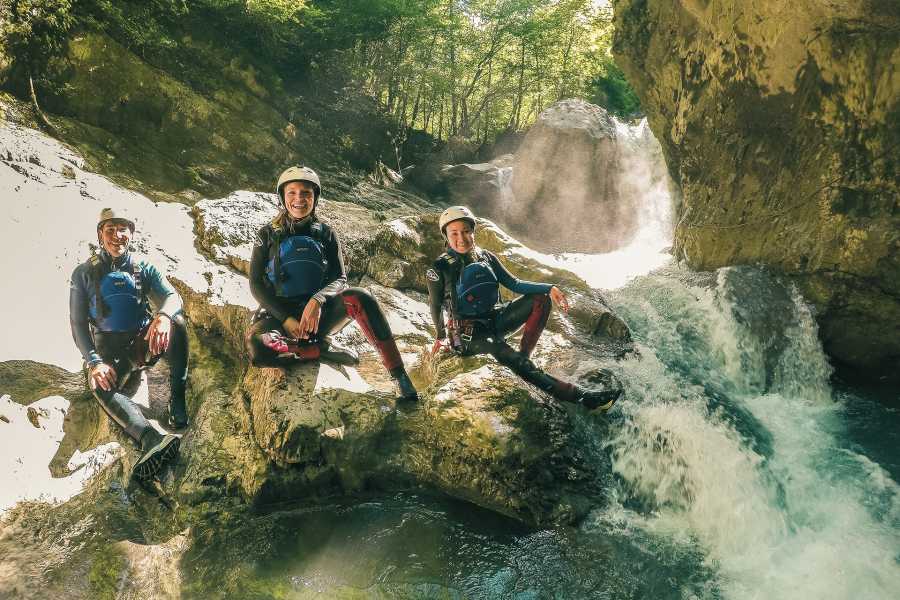 Canyoning para principiantes en la Saxetenschlucht con tres personas en trajes de neopreno junto a una cascada