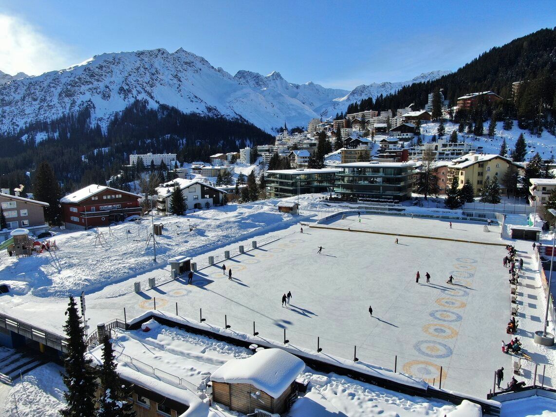 تزلج الكرات الثلجية في أروزا على السطح المتجمد أمام جبال مغطاة بالثلوج.