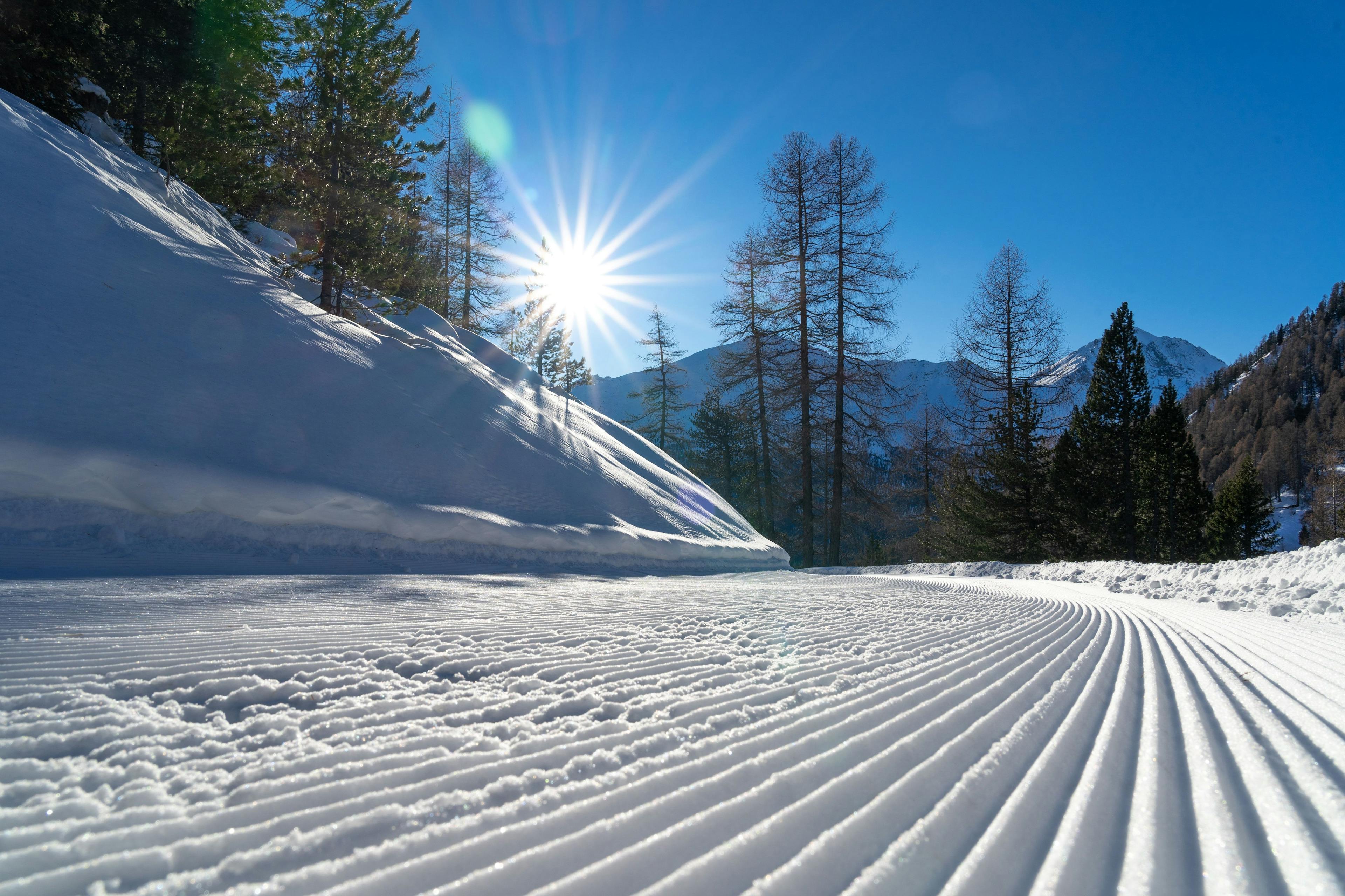 Lawinenkurs auf der Skipiste mit Schneebedecktem Boden und Bergen im Hintergrund, ideal für Skifahrer.