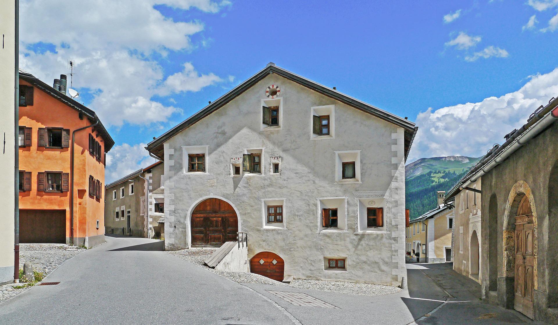 Dom Engadiner: urokliwy budynek w górskiej wiosce o historycznej architekturze i otaczających ją górach.