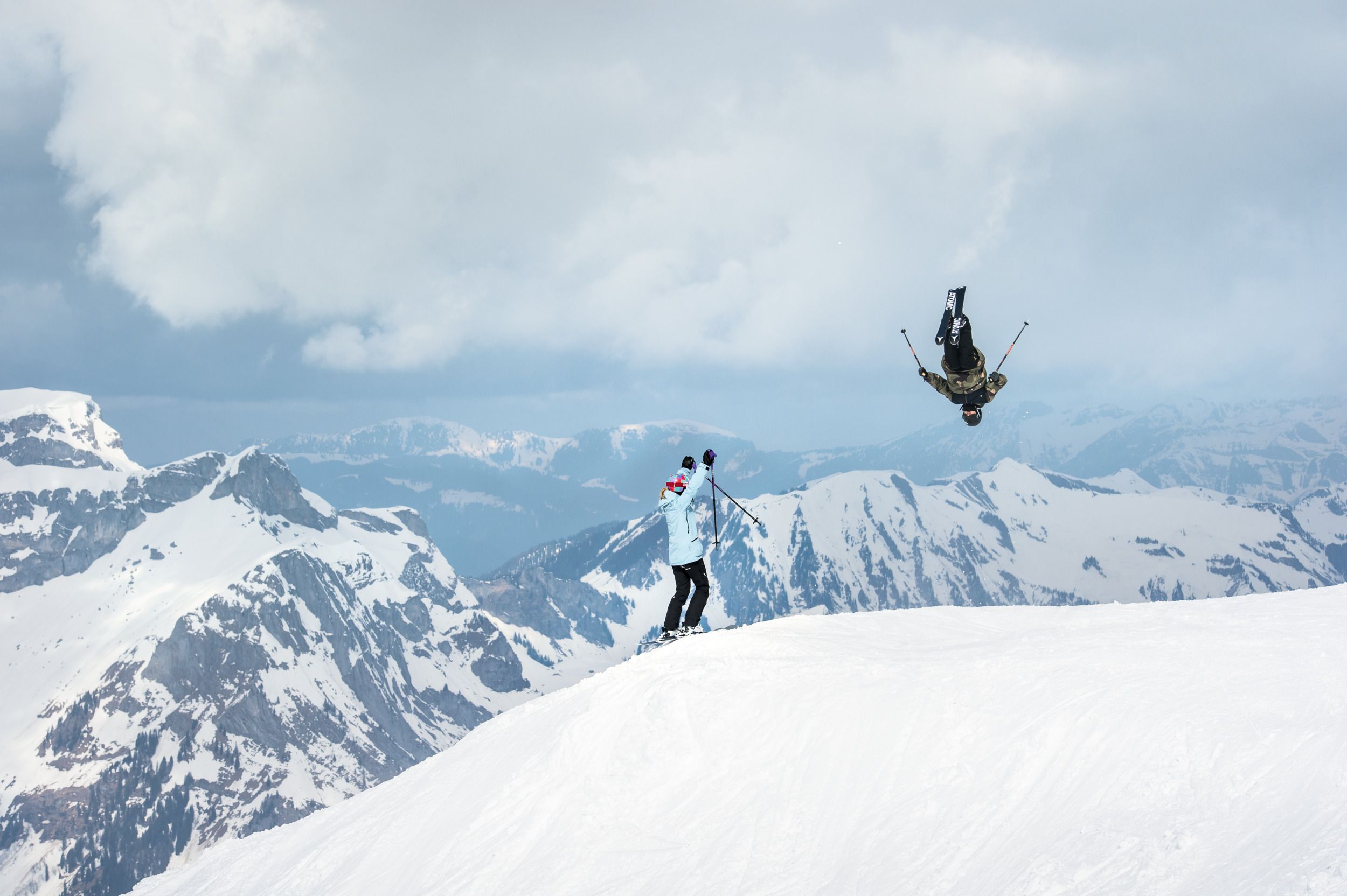 Engelberg Freeride mit Skifahrer in der Luft, Berglandschaft im Hintergrund, winterliche Bedingungen.