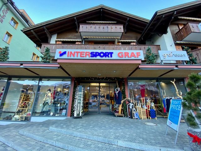 Pintu masuk Intersport Graf dengan jendela etalase dan dekorasi.