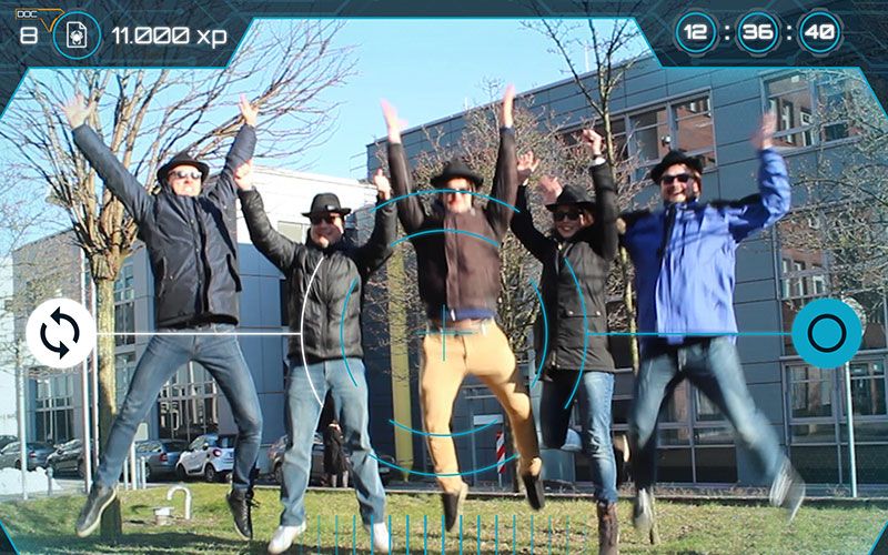 Εξωτερικό παιχνίδι απόδρασης: Ομάδα που πηδάει στην ύπαιθρο μπροστά από σύγχρονες κατασκευές.