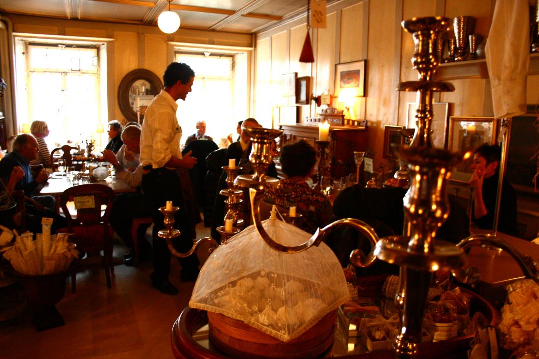 Storie gastronomiche Murten: Ristorante accogliente con ospiti, cameriere cordiale e ambiente elegante.