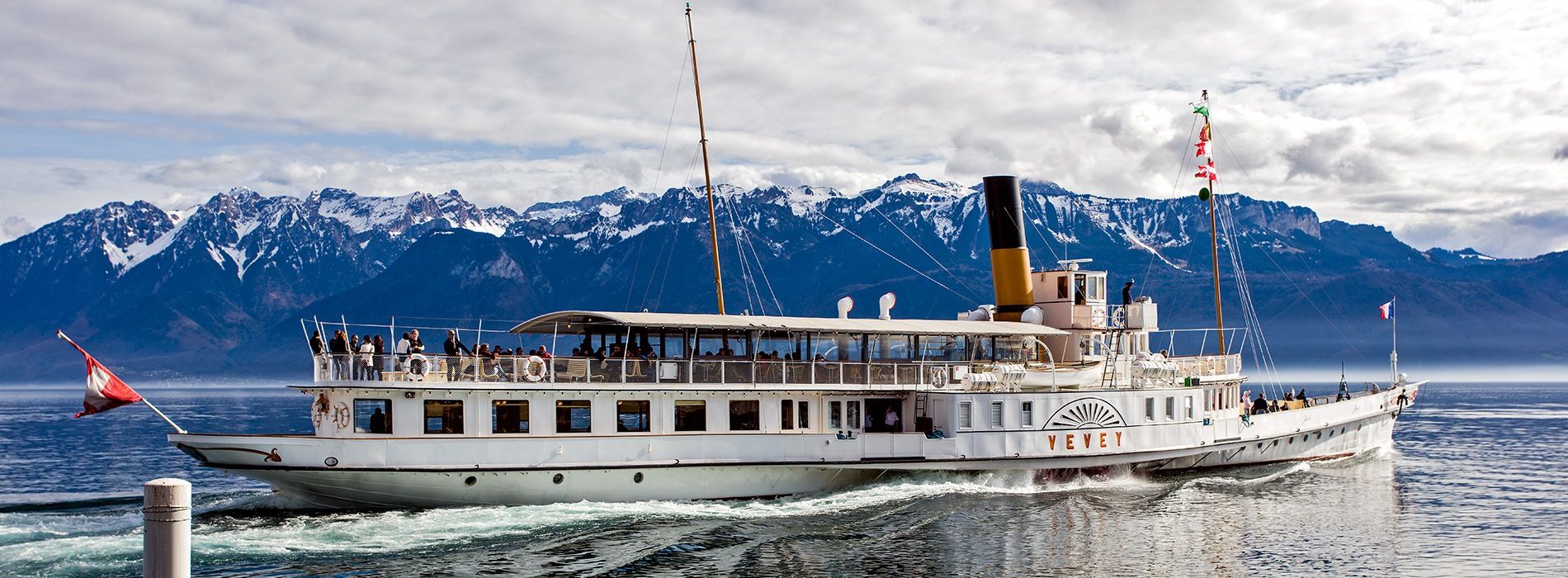 O barco Vevey navega pelo Lago Genebra diante dos Alpes.