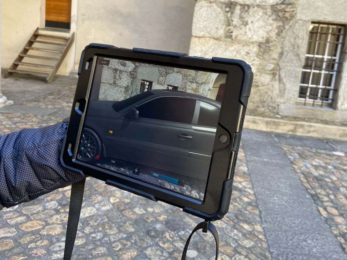 Kolor złota: tablet z widokiem na miasto z samochodem i kamiennymi budynkami w okolicy