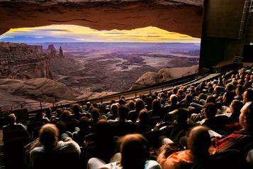 दृश्यपूर्ण परिदृश्य के सामने दर्शकों के साथ सिनेमा हॉल में फिल्म देखना