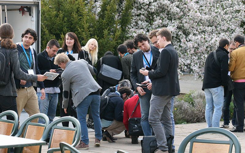 Ομαδική δραστηριότητα στο event Escape Game το 2023 στο Μόναχο με συμμετέχοντες και ανθισμένα δέντρα.