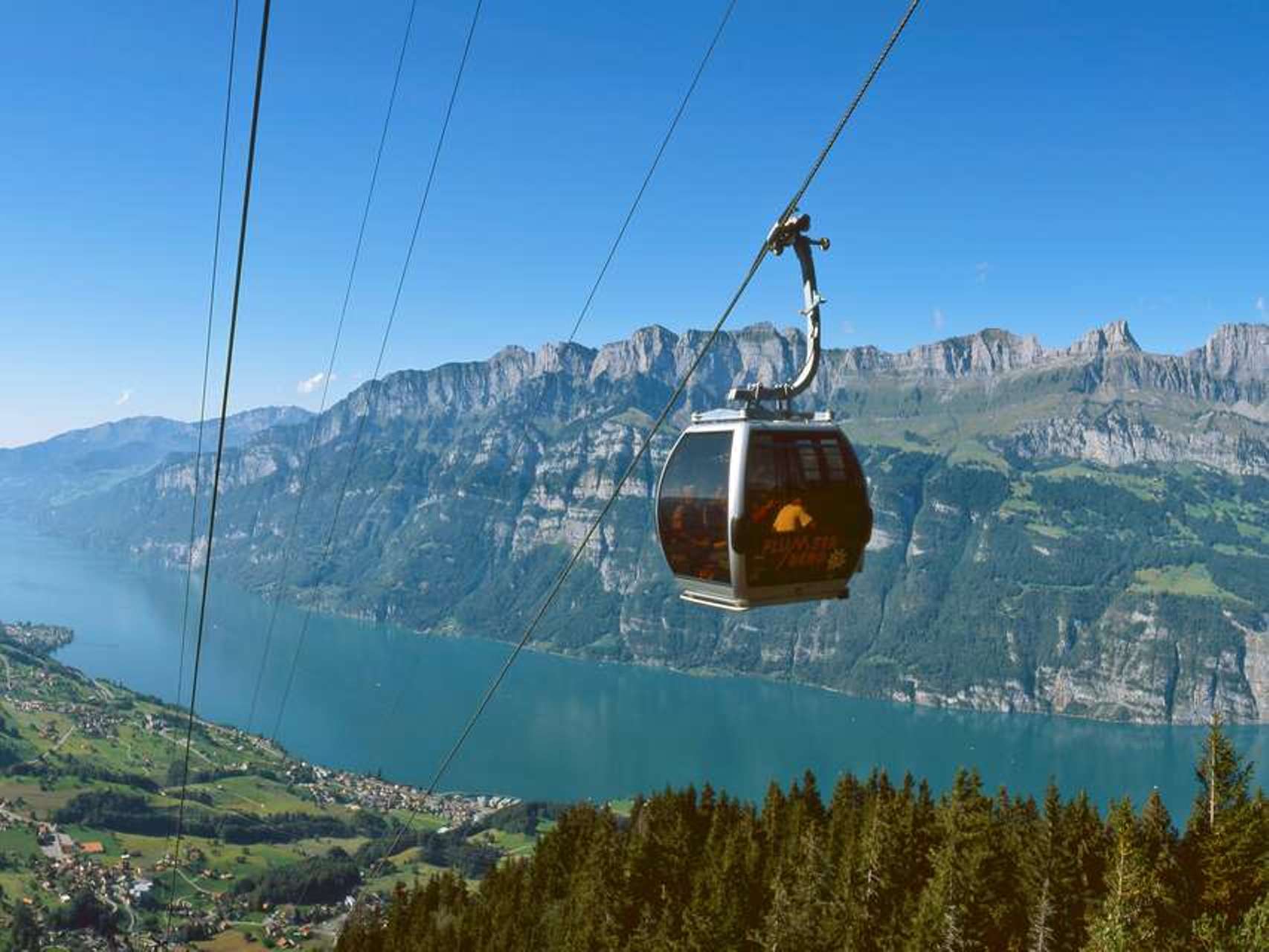 Flumserberg:s linbana åker över sjön med alpunblick.