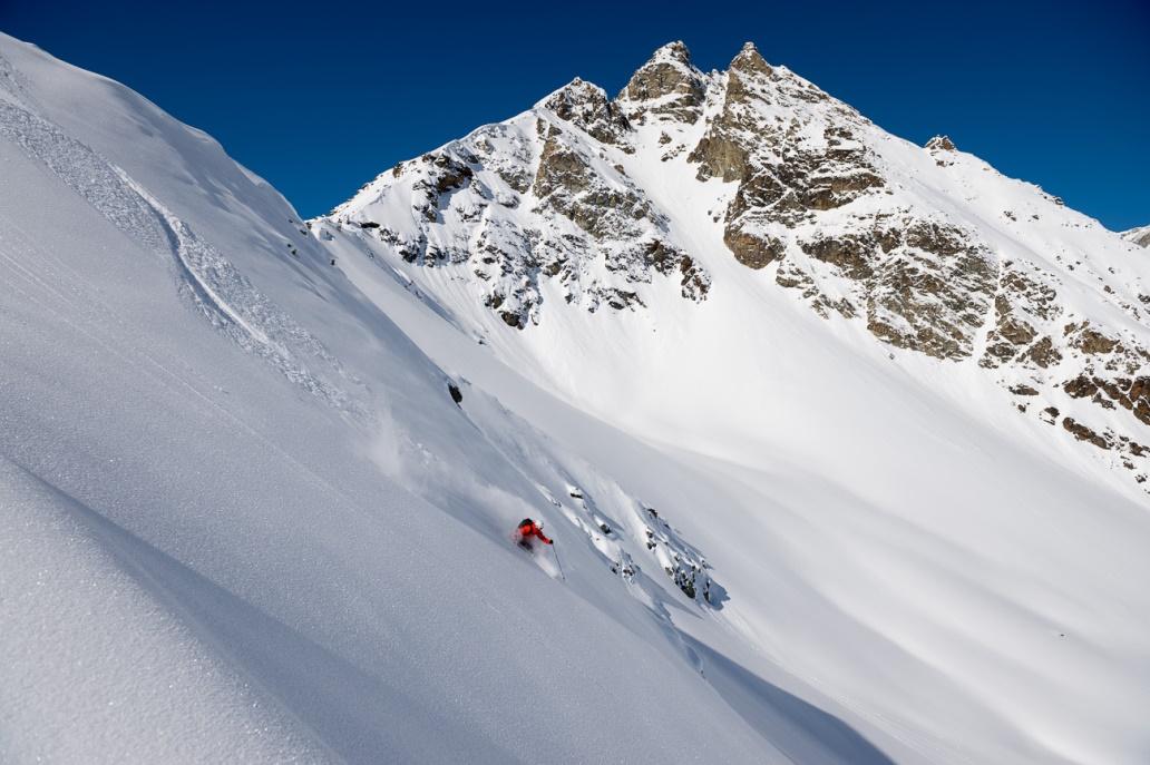 Freeride Tag: Snowboarder en una ladera cubierta de nieve en las montañas, ideal para aventuras invernales.