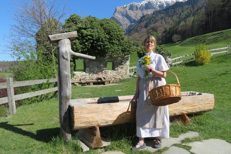 De gids laat verse bloemen zien in het Heidi-dorp.
