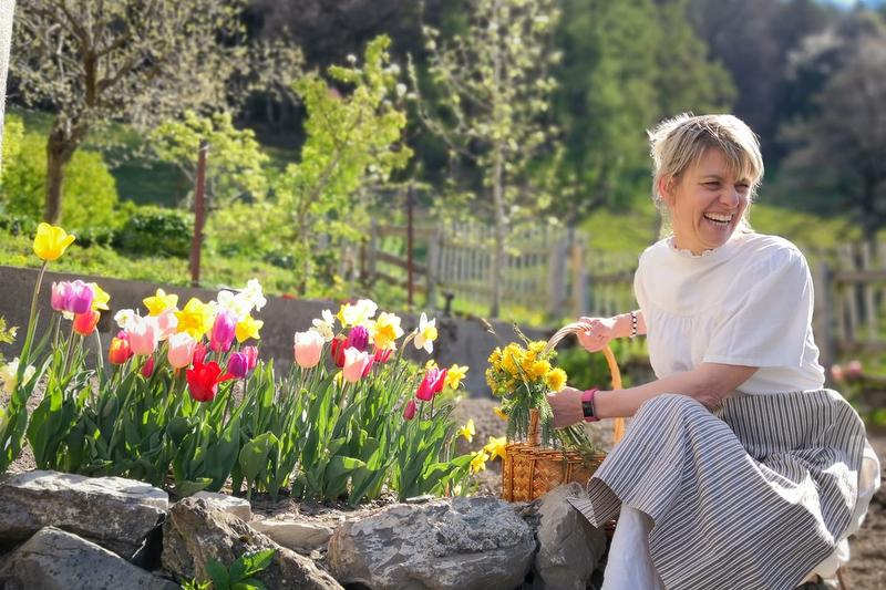 Een gids in het Heidi-dorp plukt bloemen voor kleurrijke tulpen.