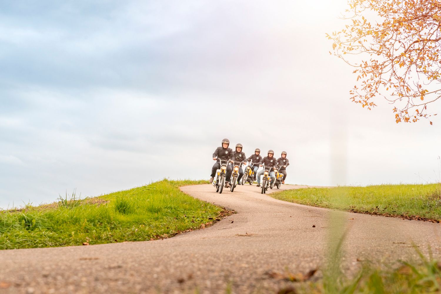 Fyrabatur: hyggelig cykeltur med venner i naturen ved overskyet stille vejr.
