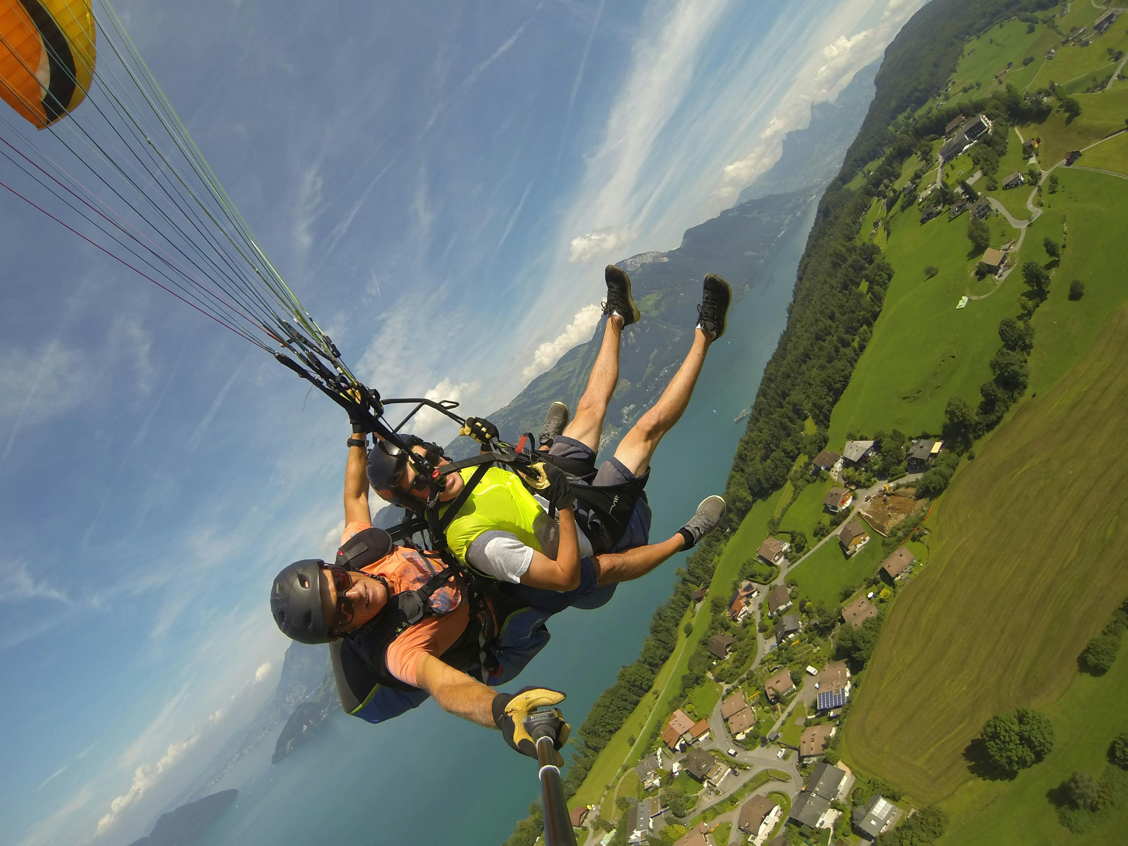 Paragliden tandem over groene heuvels en een meer