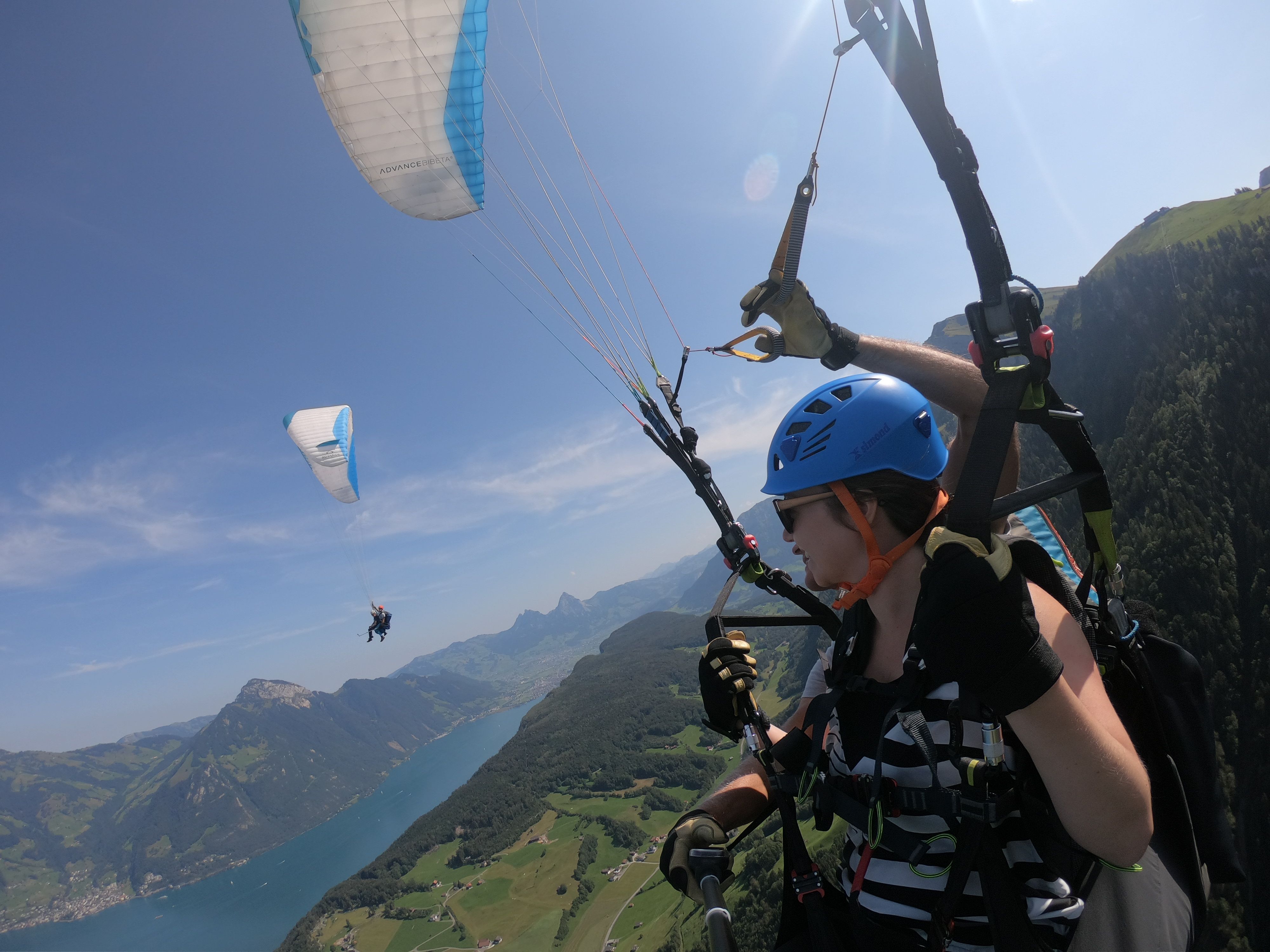 Tandem paragliding over Seelisberg in 2023 with blue skies and mountain scenery.