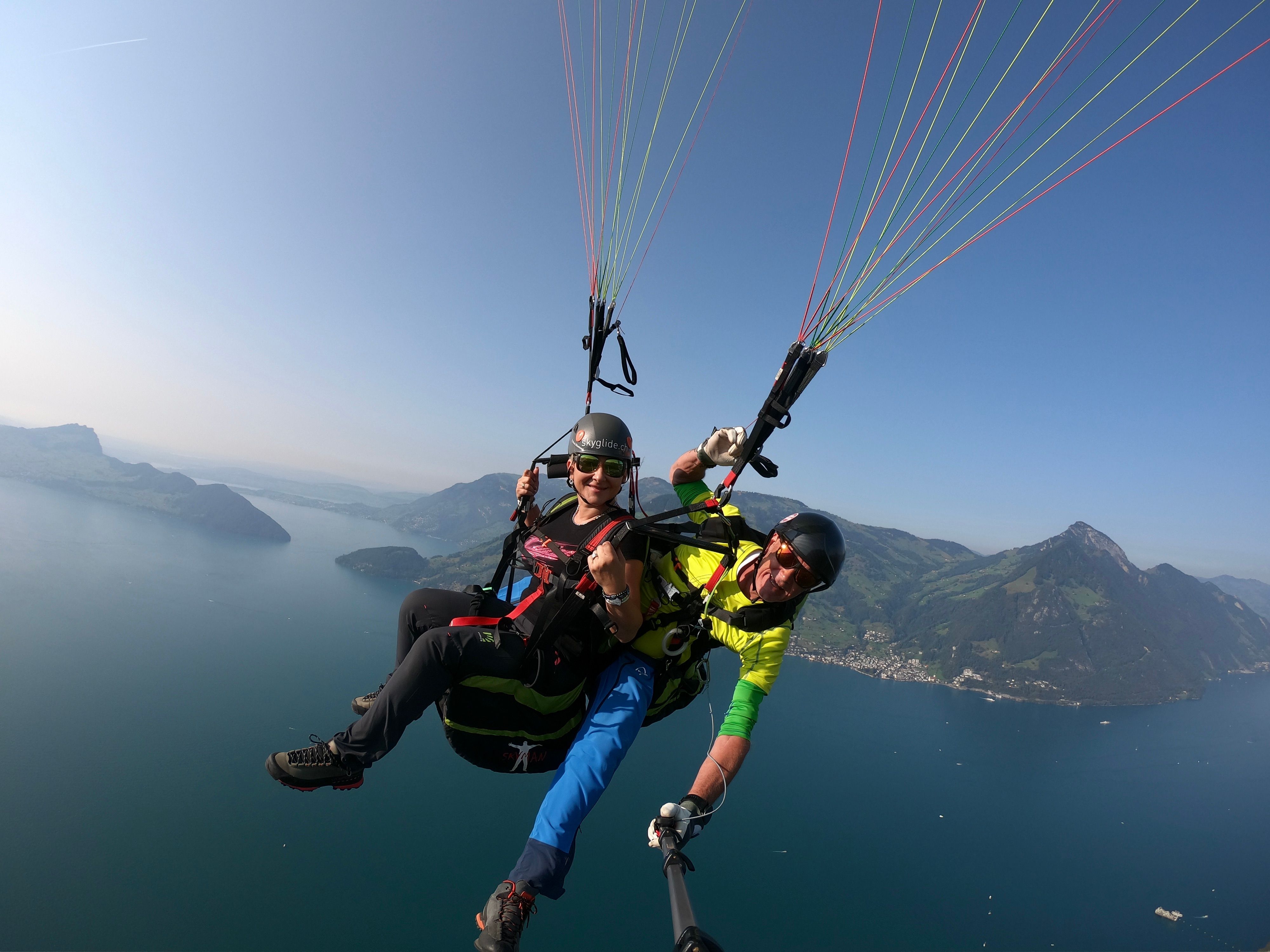 SkyGlide：在维尔瓦尔德斯特湖上滑翔伞，俯瞰山脉和蓝天。