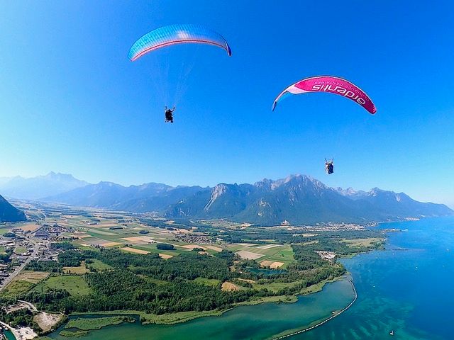 ジュネーブ湖上空のタンデムフライト、山々と緑の風景が広がる晴れた日の眺め。