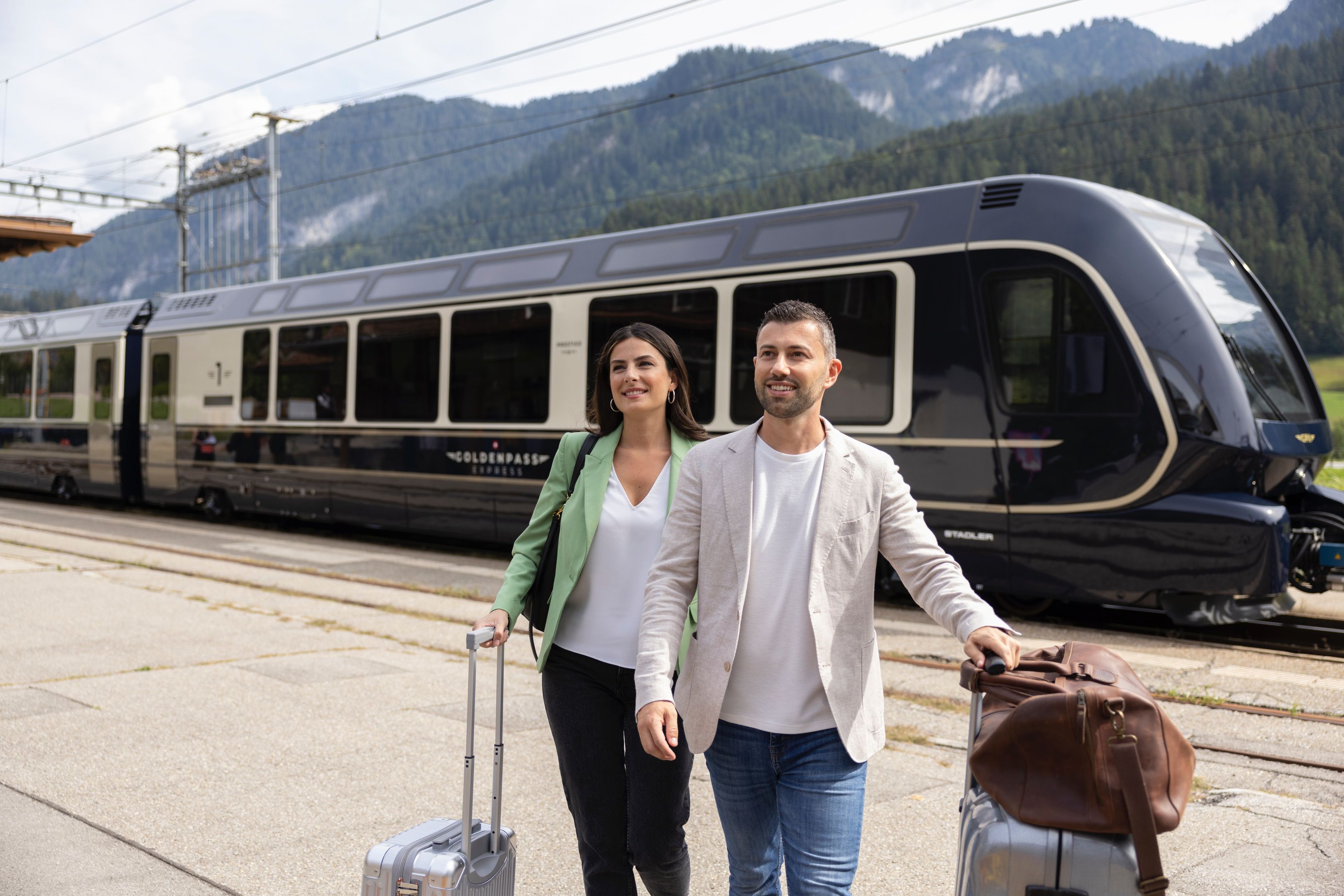 Golden Pass Line: ผู้โดยสารที่สถานีรถไฟพร้อมกระเป๋าในเขา เหมาะสำหรับการท่องเที่ยวแบบโรแมนติก.