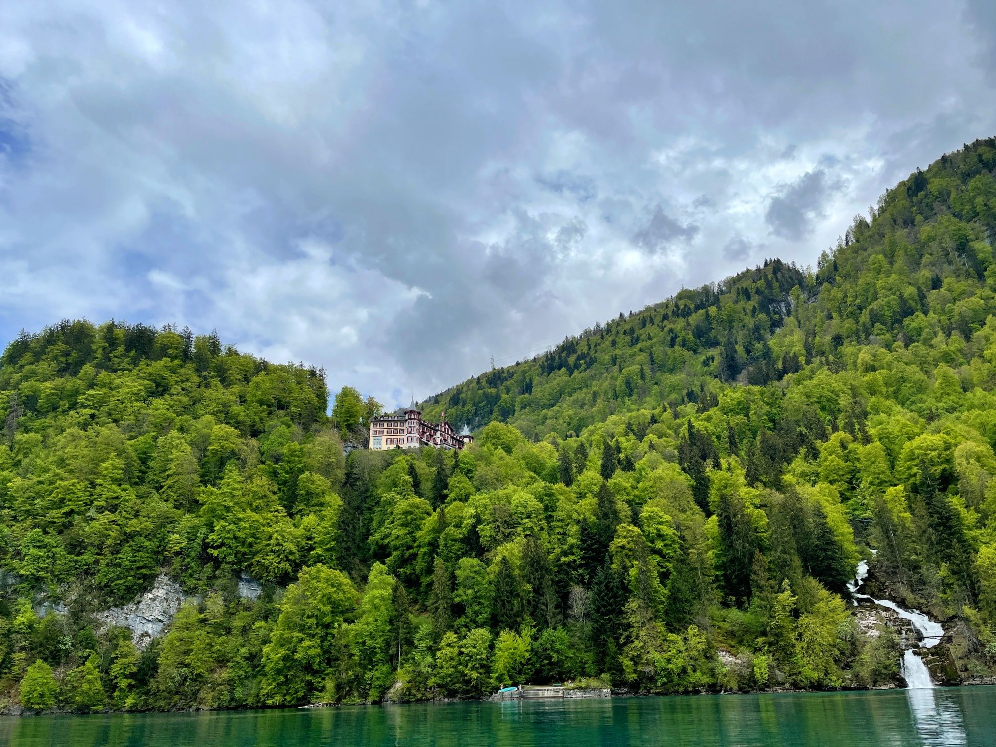 Cascadas de Giessbach: vista de la naturaleza verde con cascada y hotel histórico en los alrededores.