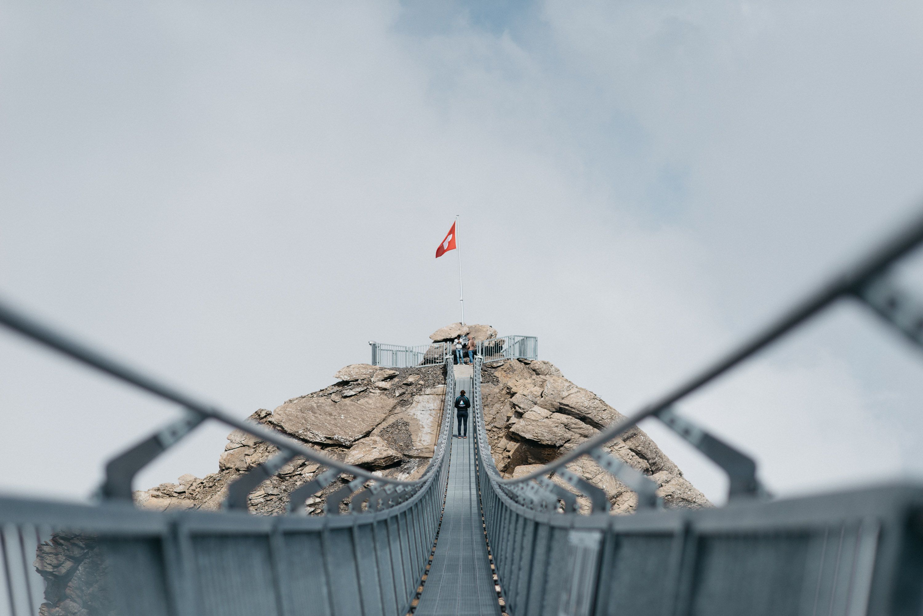 구름 낀 하늘 아래 다리 위에 있는 사람들과 함께하는 글래시어 3000 산책