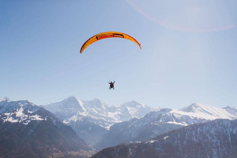 인터라켄의 눈 덮인 산들 위에서의 패러글라이딩