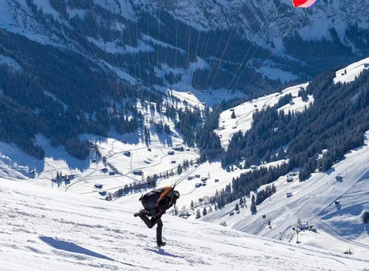 Paragliding Tschentenalp, Person with paraglider, winter landscape