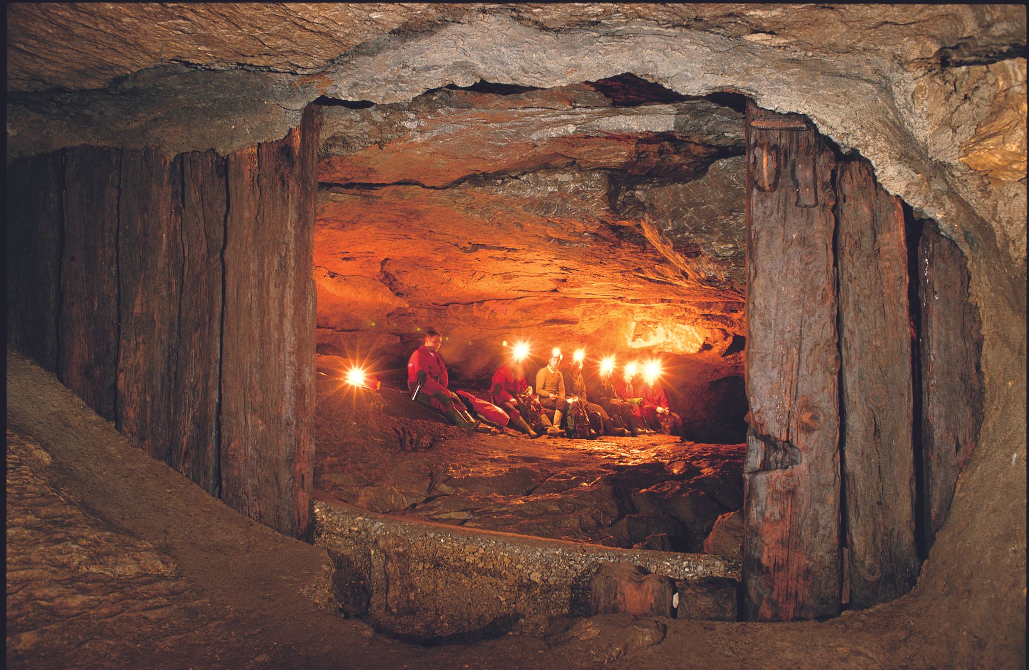 Puerta de brillo con visitantes de cuevas sosteniendo velas
