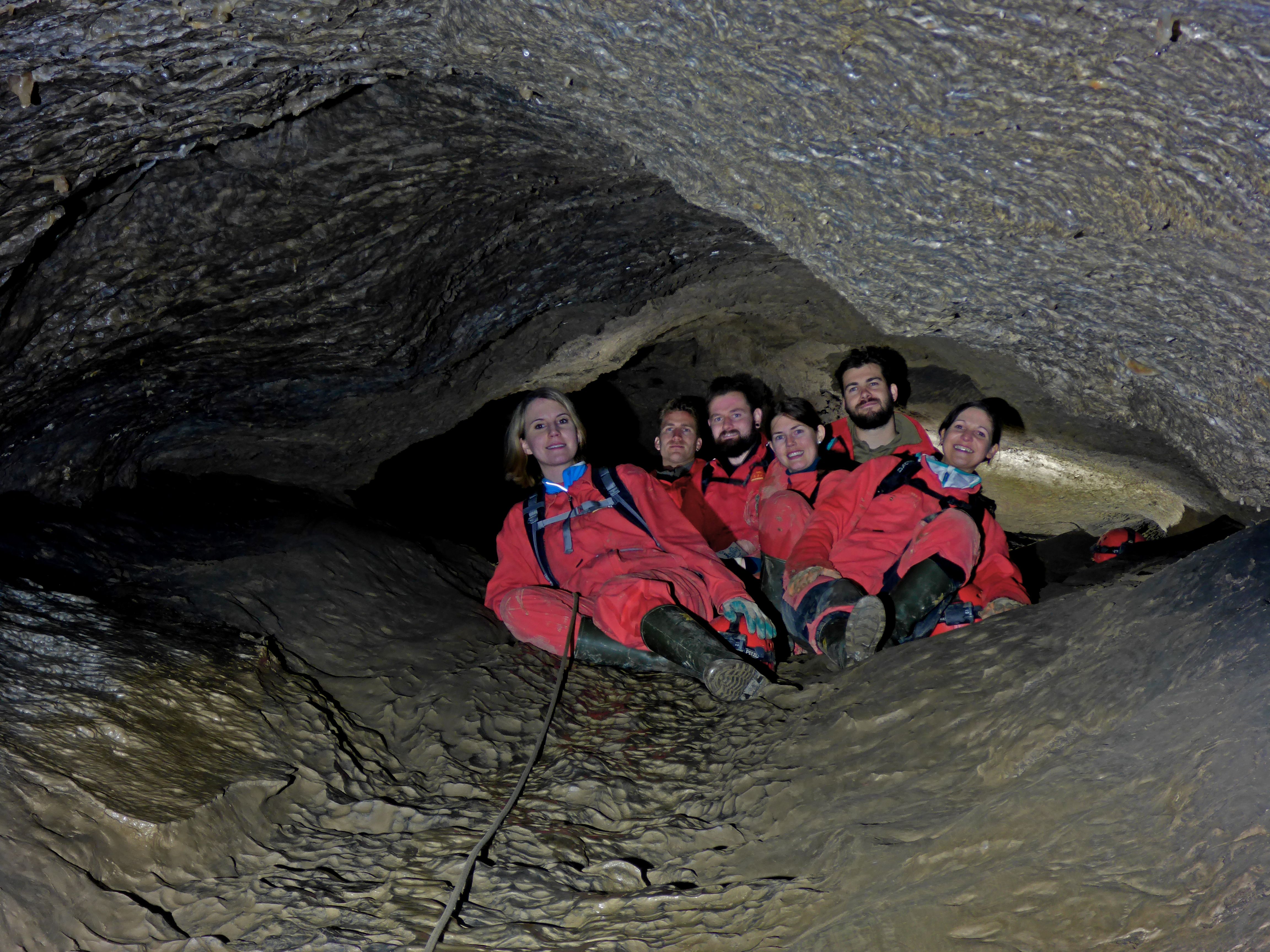 Skupinová exkurze do Hölloch s účastníky v ochranném oblečení u vchodu do jeskyně.
