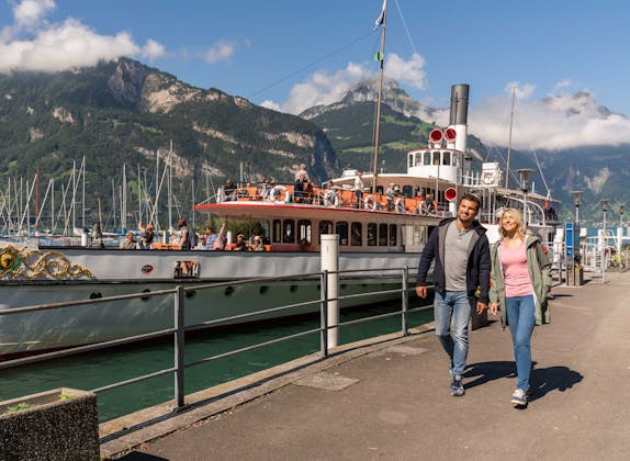 Skift fra fartøy til tog i Flüelen, pittoresk landskap og romantisk utsikt ved Vierwaldstättersee.