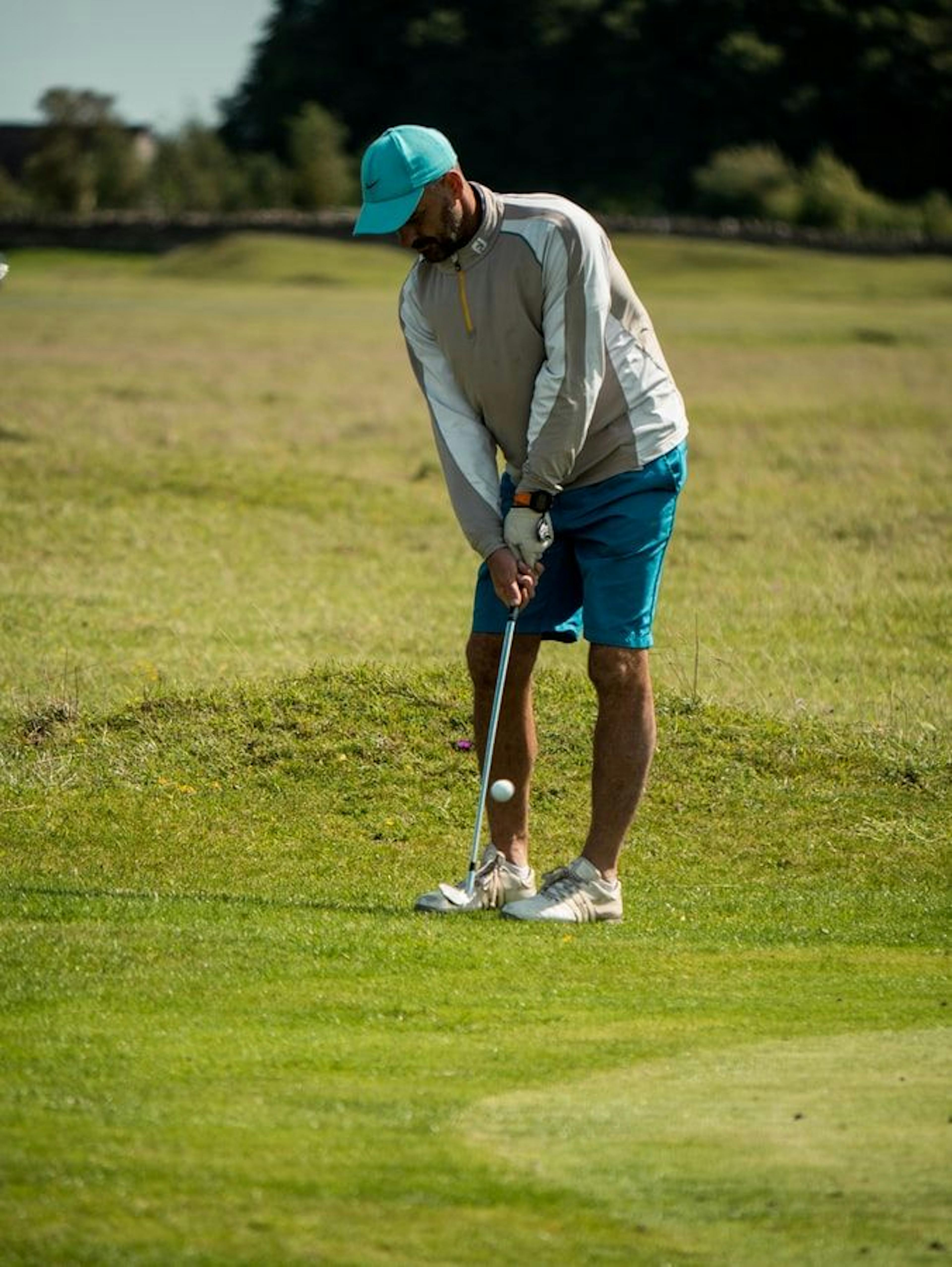 Giocare a golf nel campo sportivo, giocatore con la mazza, paesaggio erboso.