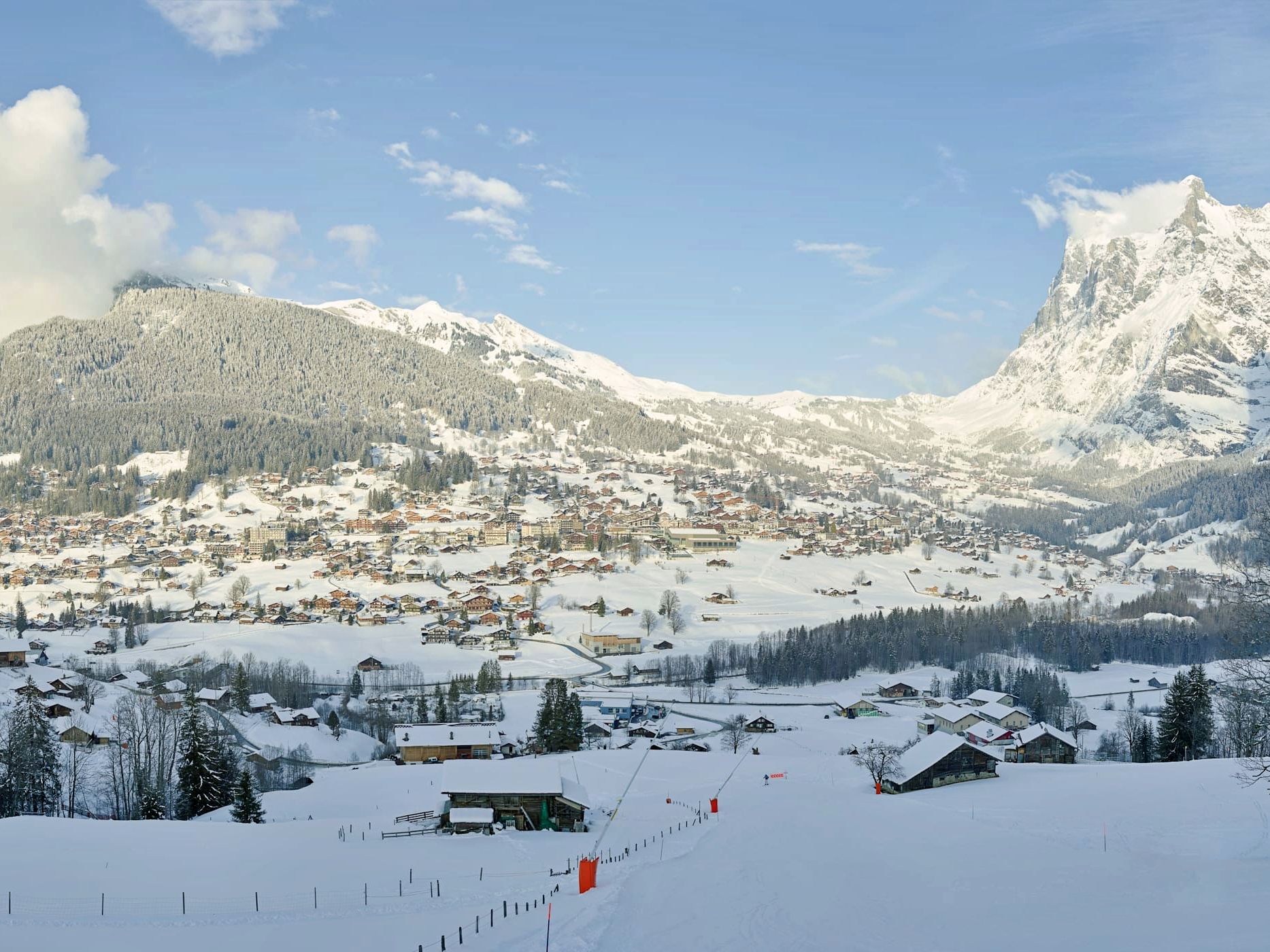 Gizdă penguinii iarna, cu munți acoperiți de zăpadă și cabane