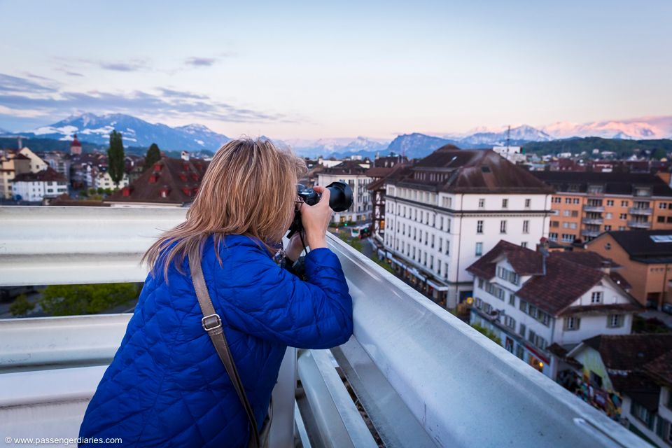 Photography Course Lucerne, participant photographing cityscape, a moderately cloudy evening sky.