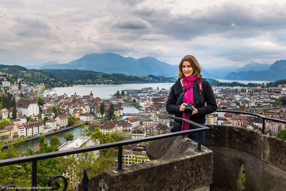 Cours de photographie à Lucerne : Une participante avec un appareil photo se tient à un point de vue, regardant Lucerne et ses environs