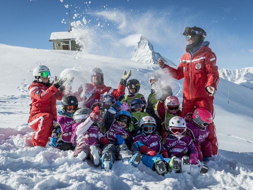 Zermatt Ski School: Children in the snow skiing and playing, group lessons in winter.