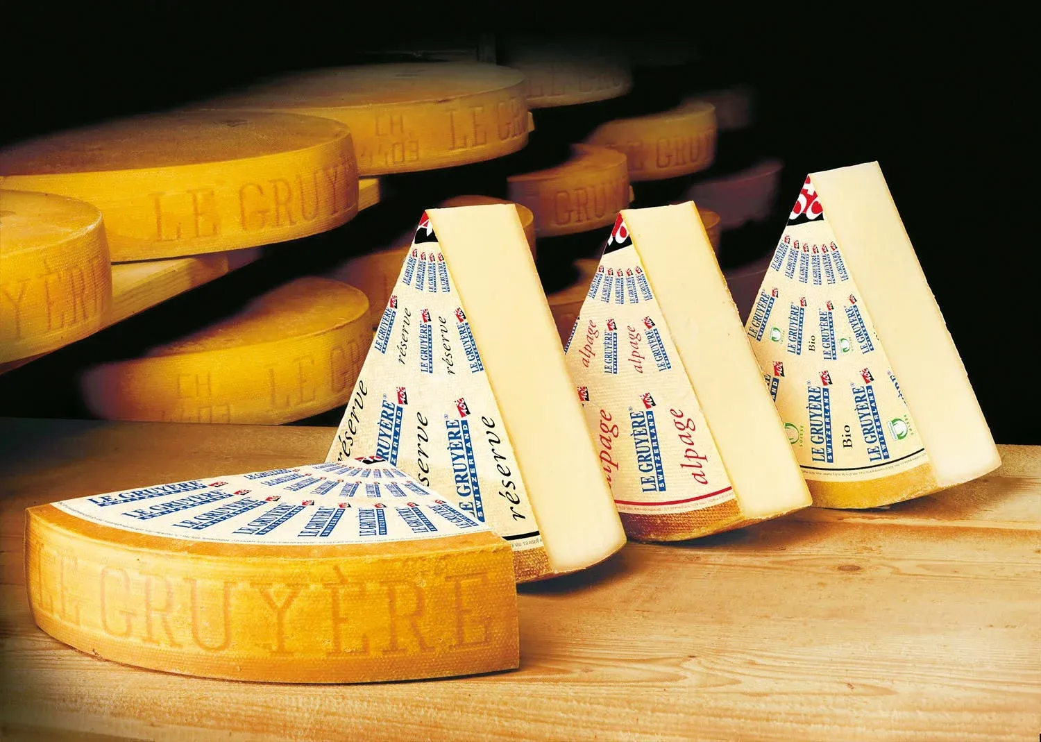 Gruyère AOP Käse mit Etiketten auf Holztisch