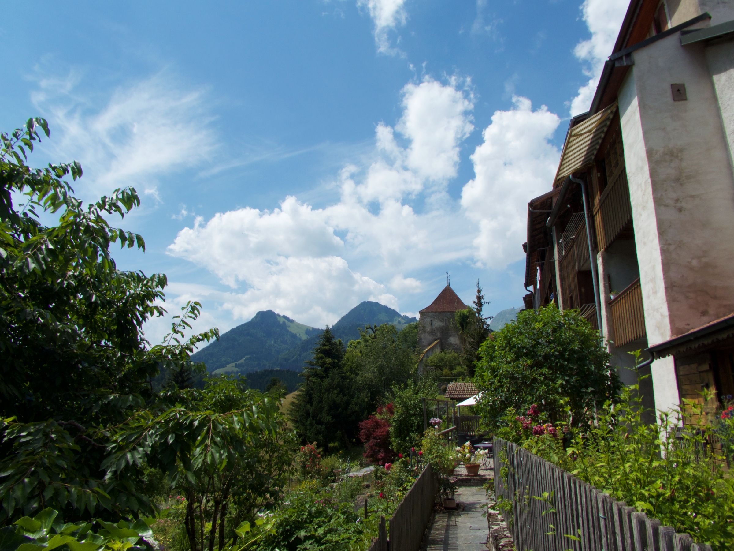 Gruyères: arkitekturë piktoreske me pamje nga malet dhe natyra në verë.