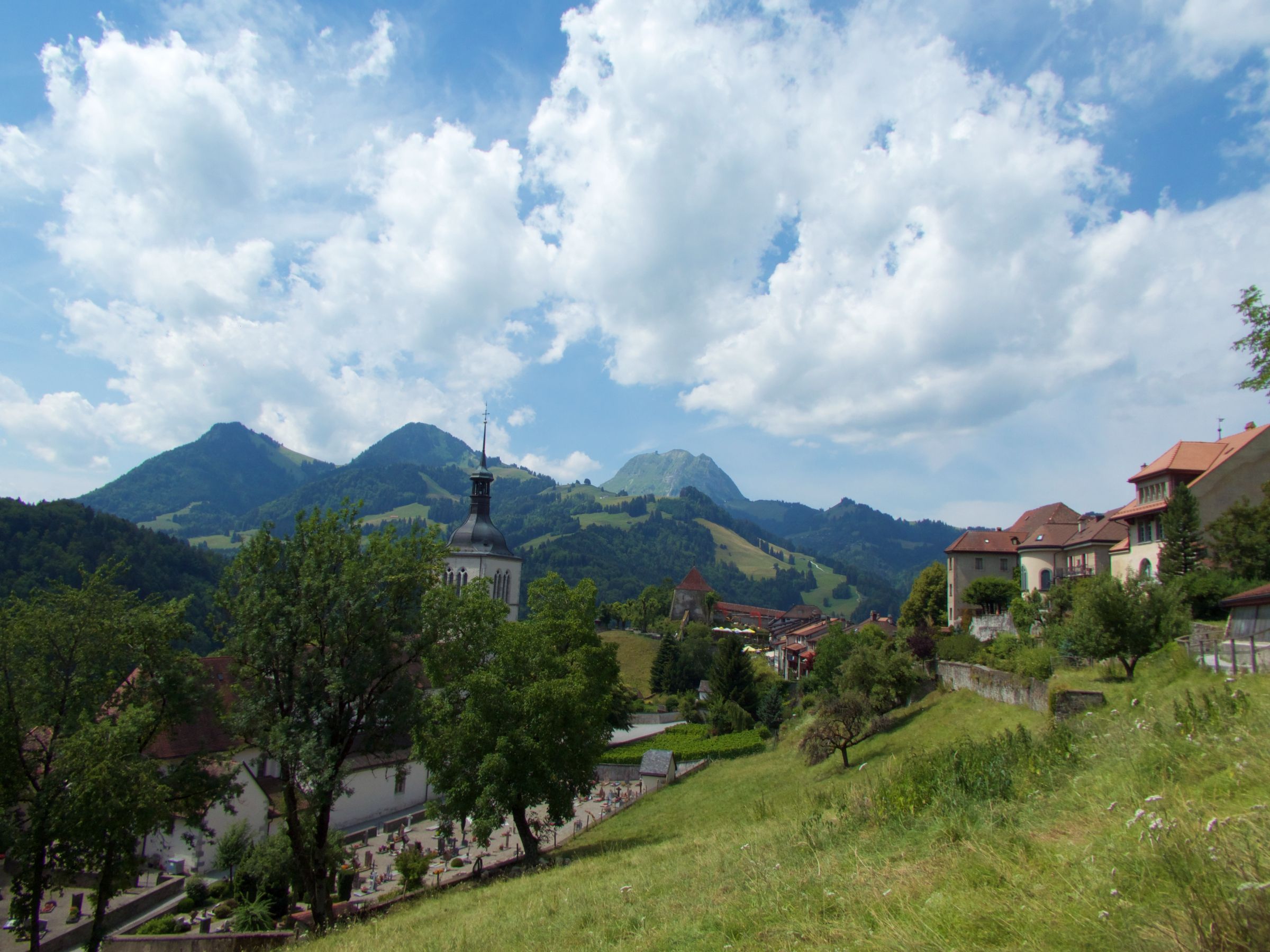 Gruyeres: peisazh piktoresk me male dhe re mbi qytet, ideal për adhuruesit e natyrës.