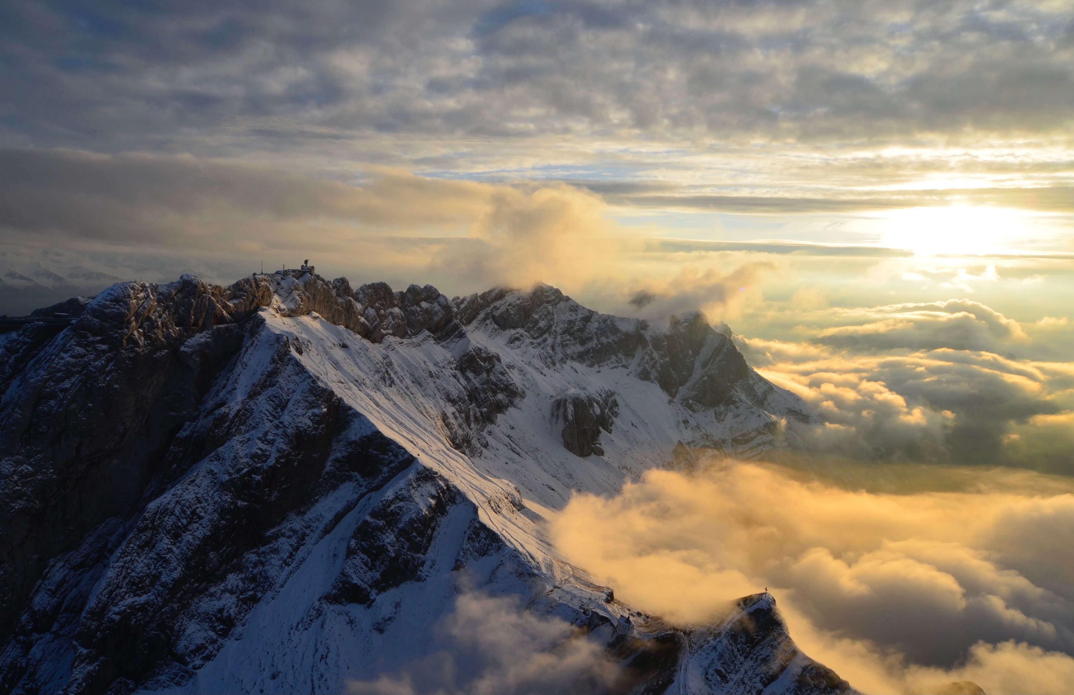 جولة بالطائرة الهليكوبتر فوق جبال الألب مع إطلالة على غروب الشمس والسحب.