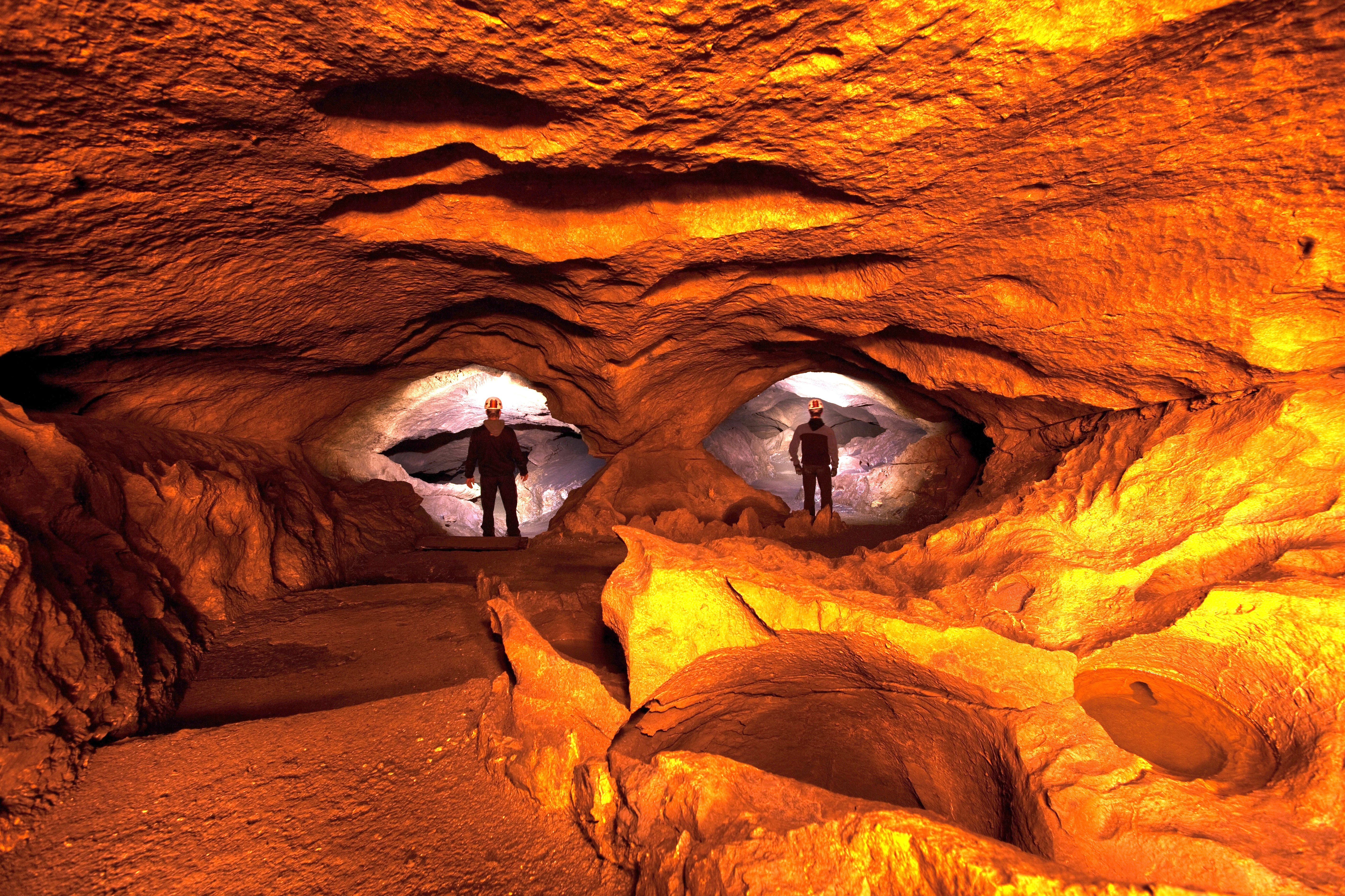 Hölloch grotta med två forskare i skyddskläder.