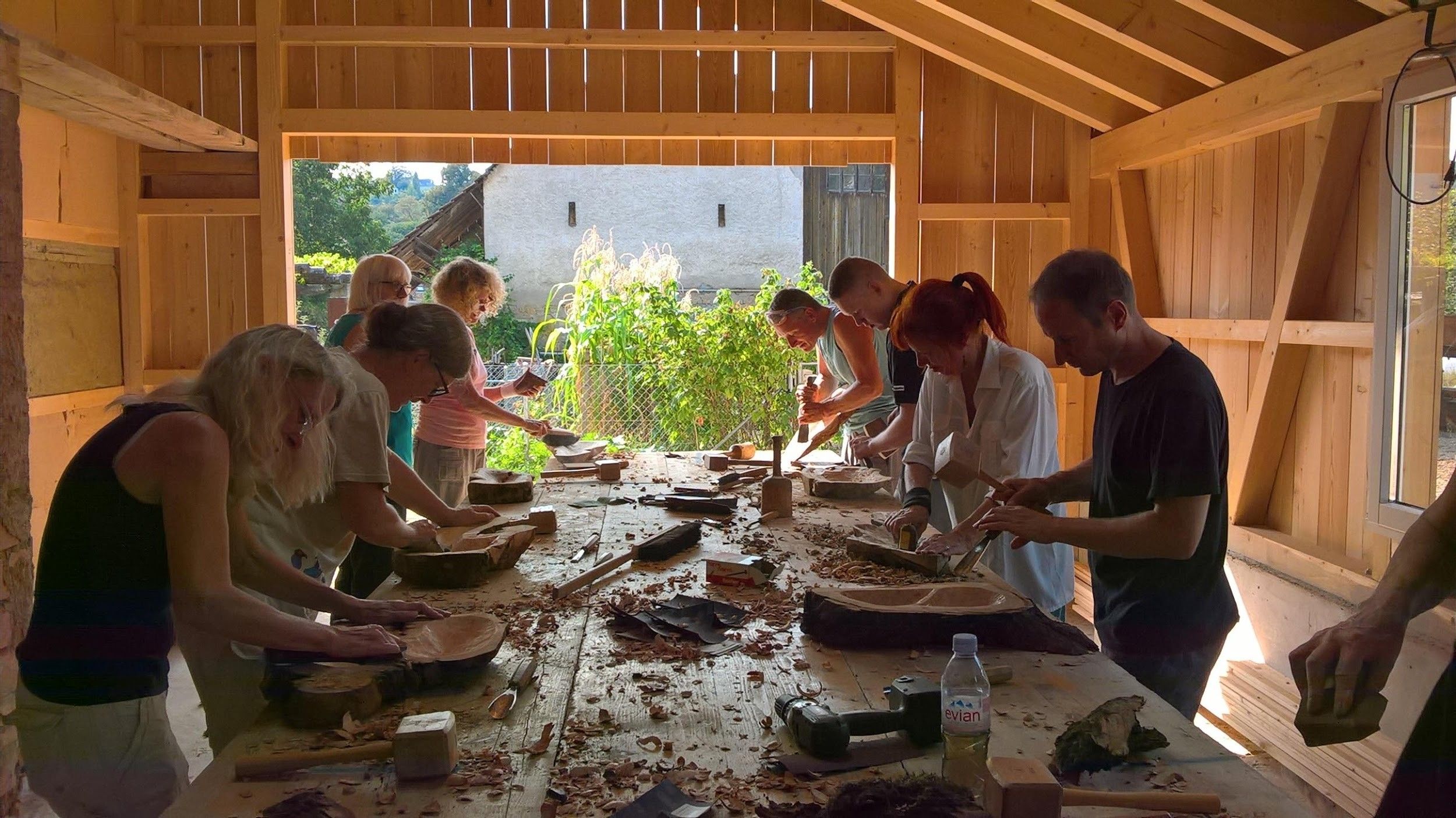 在创意工作坊中与团队一起雕刻木碗。