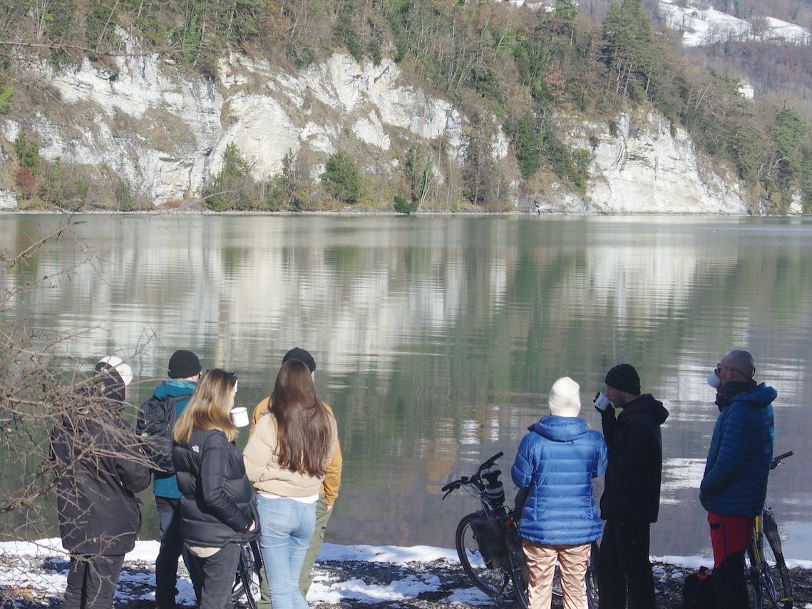 Passeio de bicicleta: Grupo admira o lago tranquilo na natureza durante um passeio de bicicleta no verão.