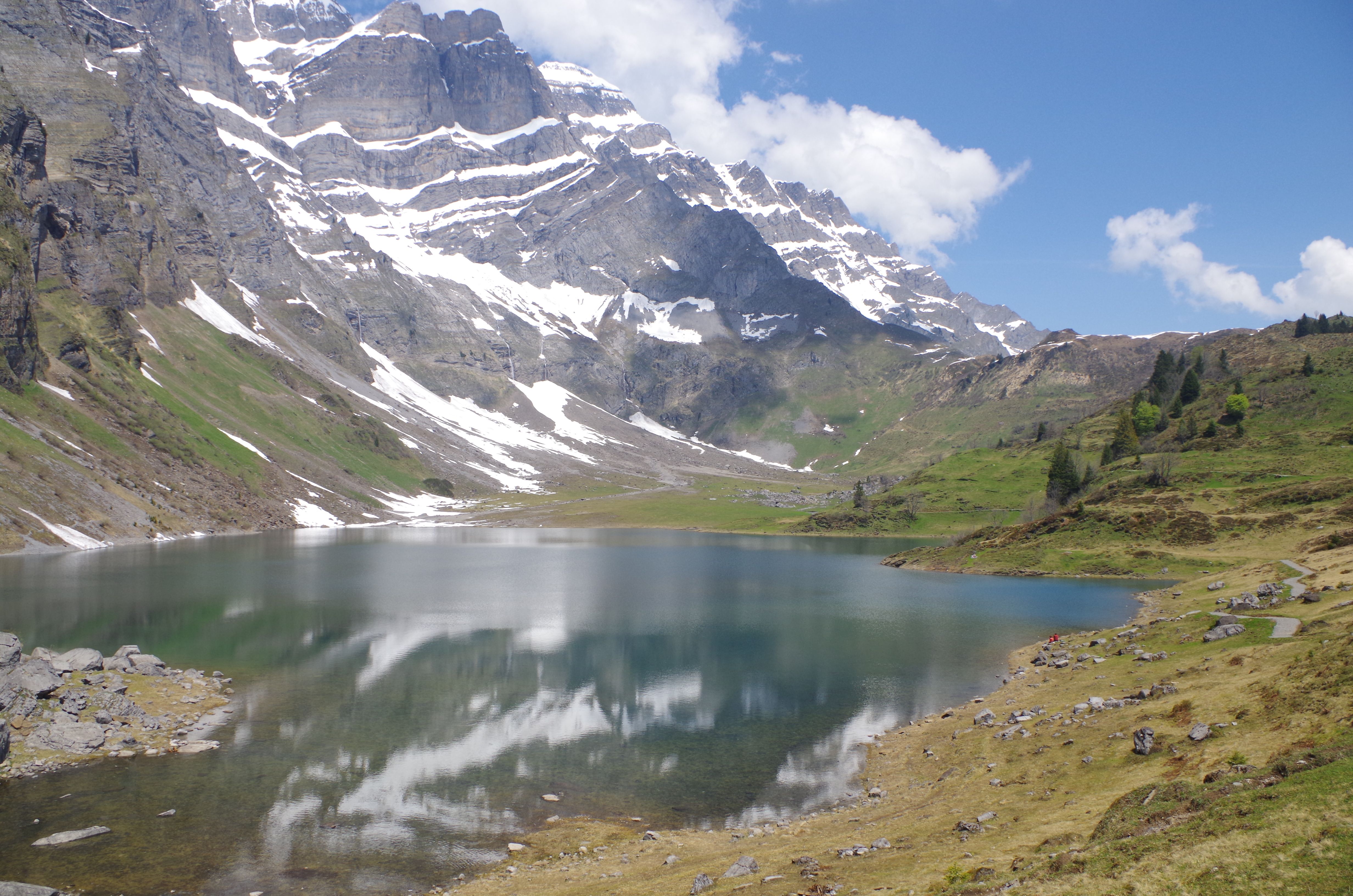 Curso de Alphorn no Oberblegisee com vista para as montanhas e o lago claro, ideal para amantes da natureza.