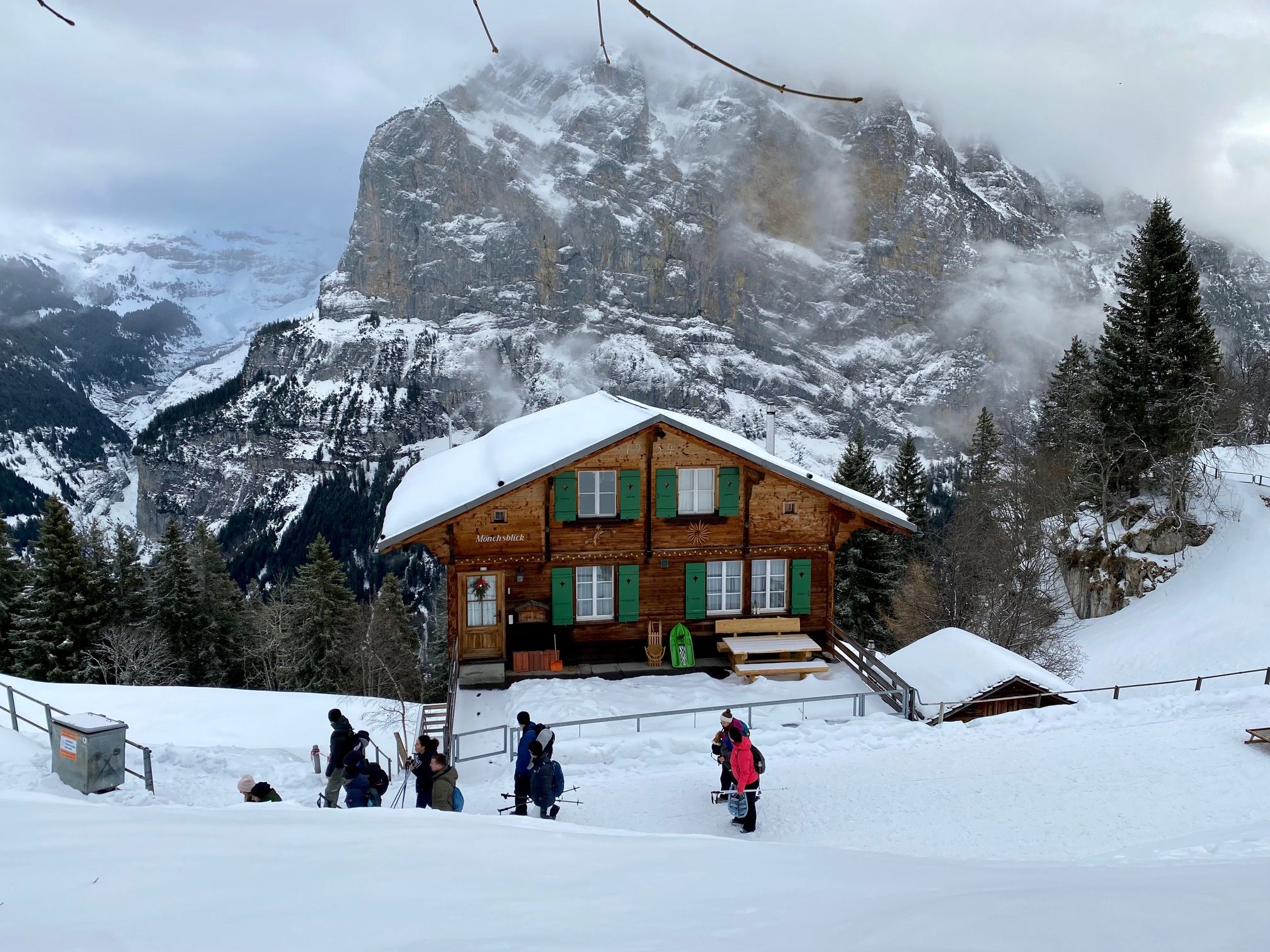 Zimní krajina v oblasti Jungfrau s útulným dřevěným domem ve sněhu, ideální pro dobrodružství.