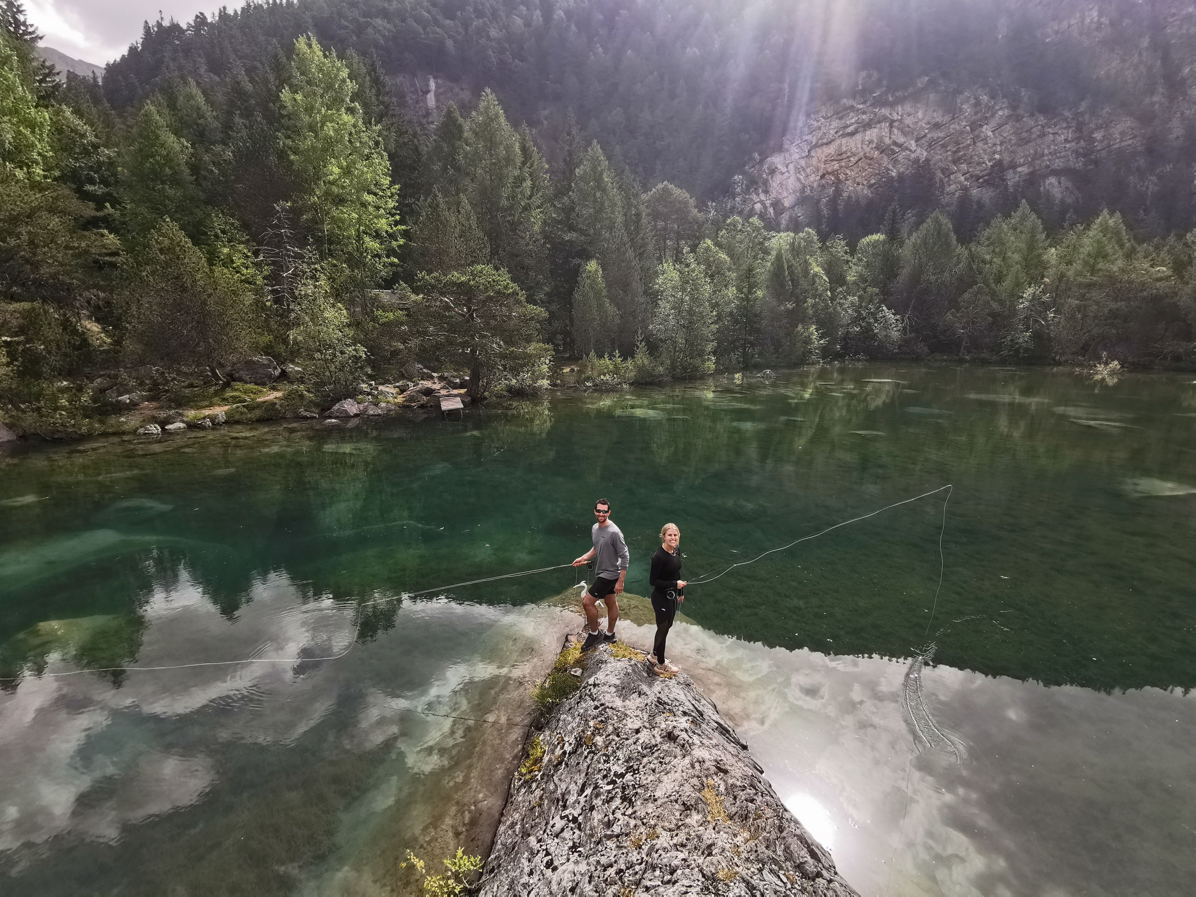 Swiss Flyfishing: två fiskare vid den klara sjön i naturen i Derborence, perfekt för äventyr.